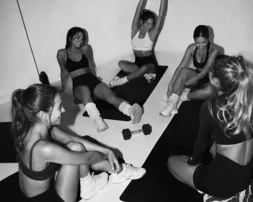 Grupo de mulheres alongando e sorrindo depois do treino